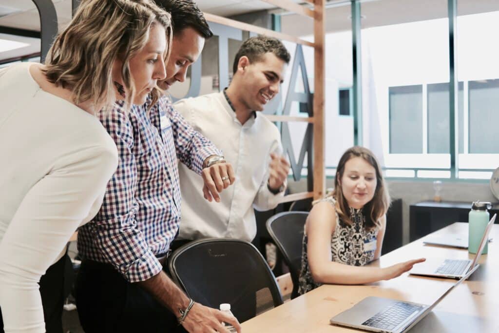 Ein fröhliches Team, das an Computern arbeitet und dabei Microsoft Viva Glint verwendet.